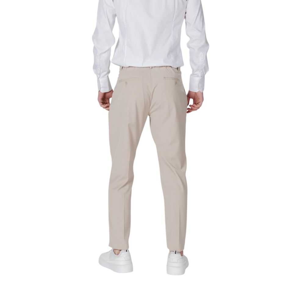 Back view of Antony Morato Beige Polyester Pant with regular fit and welt back pockets, worn by a model in white sneakers.