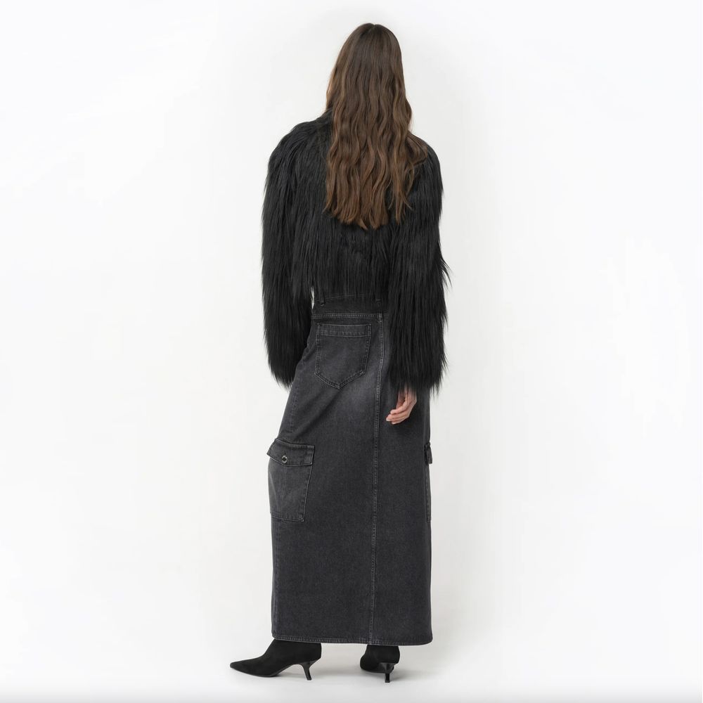 Woman wearing PINKO Black Cotton Skirt with zip closure and flap pockets, standing with back view showcasing style and design