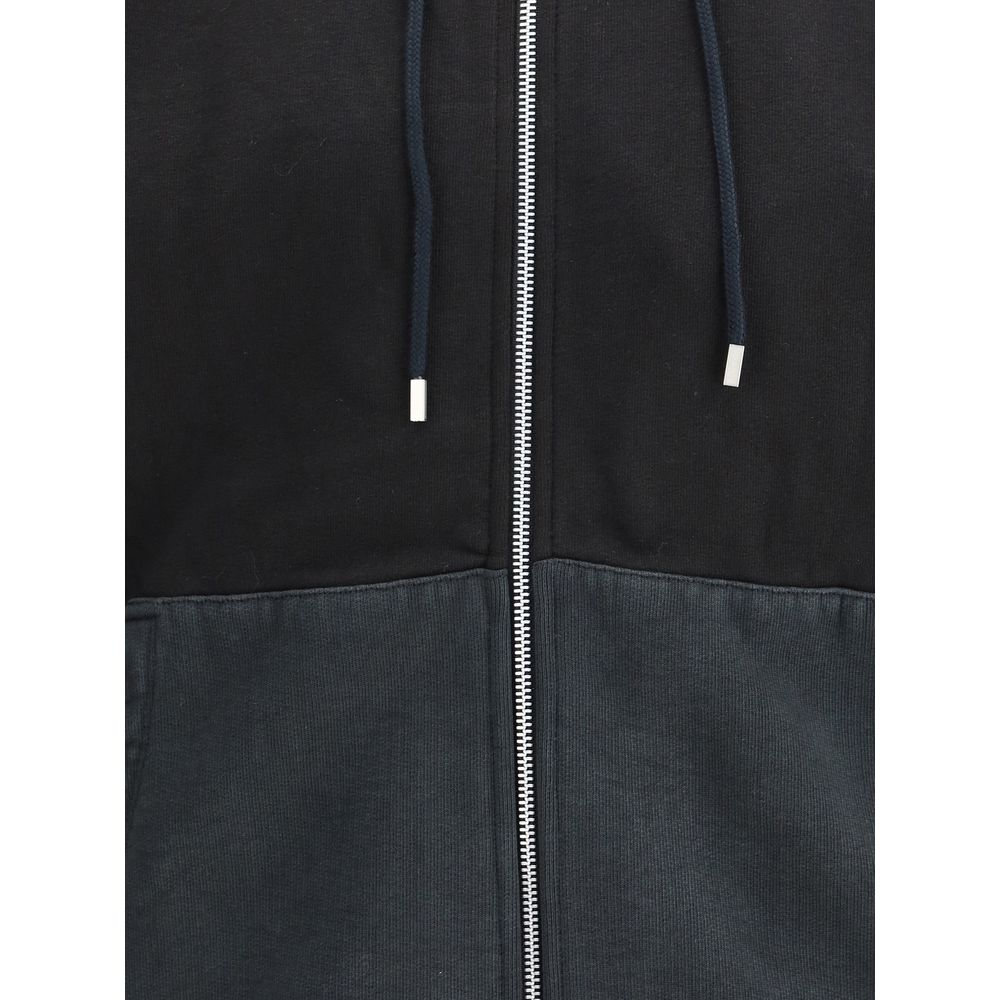 Close-up of Our Legacy Black Cotton Sweatshirt with drawstring hood and zip detail.