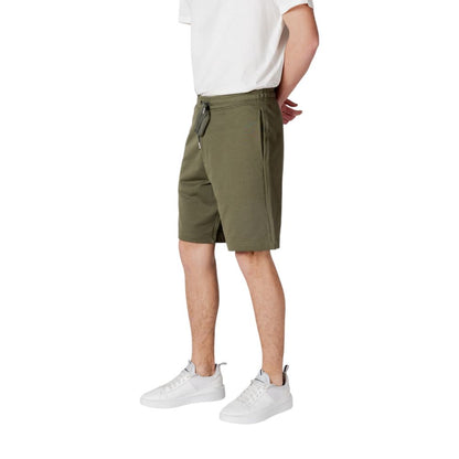 Model wearing Replay Green Cotton Bermuda Shorts with white sneakers and a white t-shirt, showcasing comfortable and stylish summer fashion.