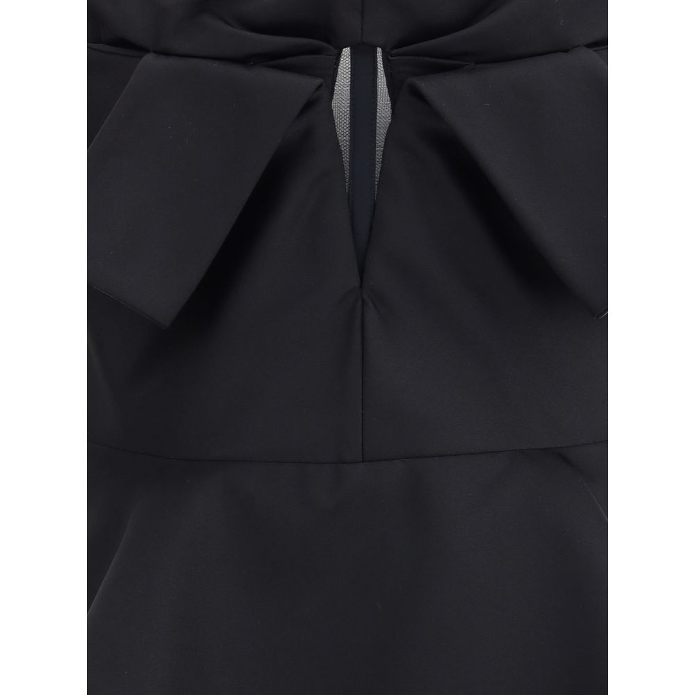 Close-up of Alexander McQueen Black Polyester Top showing bow detail and peplum silhouette.