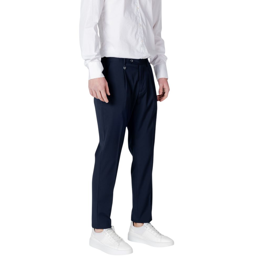 Model wearing Antony Morato Blue Polyester Dress Pants with regular fit, front pleats, button and zip closure, side and welt back pockets.
