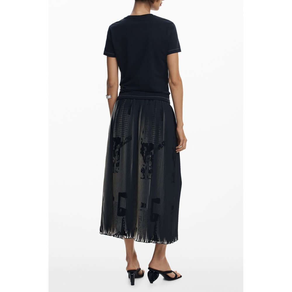 Woman wearing Desigual Black Polyester Women Skirt with pleats and newspaper motifs, showcasing a chic and bold style.