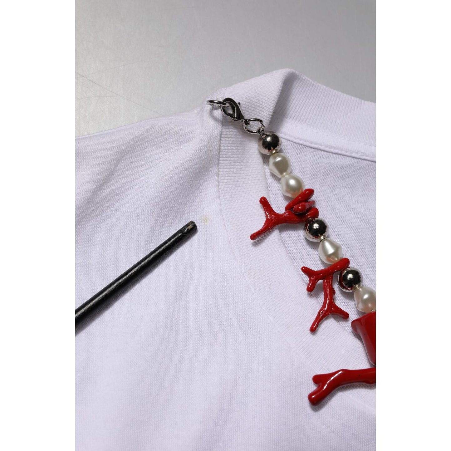 Close-up of Dolce & Gabbana White Embellished Cotton Crew Neck T-shirt with embellishments and minor stain detail.