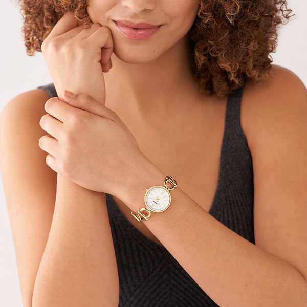 Woman wearing FOSSIL Mod. ES5272 wristwatch, 30mm SS IP Gold case, water resistant 5 ATM, quartz movement, with mineral dial.
