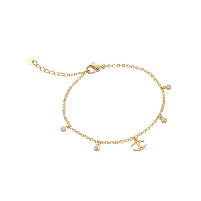 Gold bracelet with charm details on white background.
