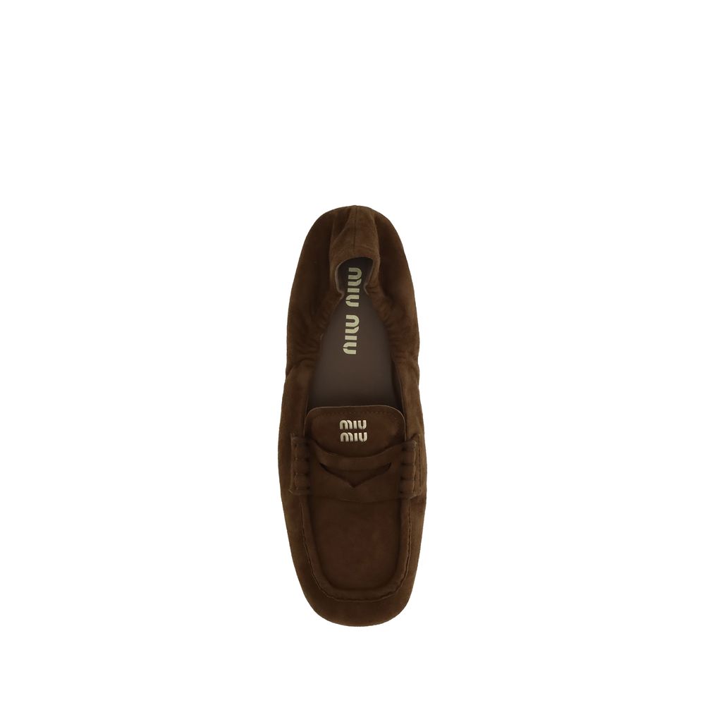 Miu Miu Brown Calf Leather Bos Taurus Slip-On Loafers with leather horsebit, embossed logo, and rubber sole for stability.