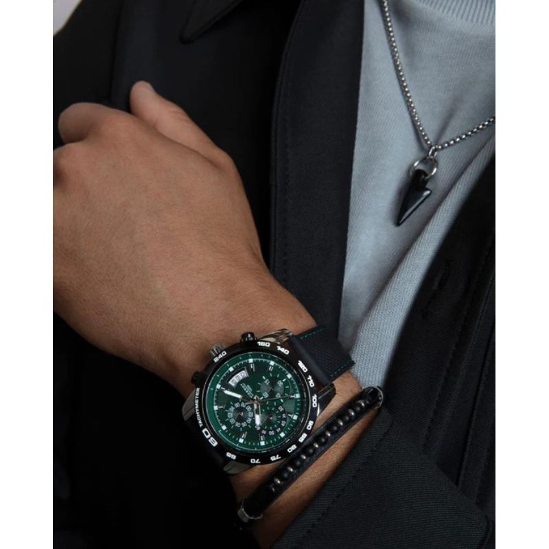 Man wearing watch and necklace photographed in close-up with focus on details and accessories.